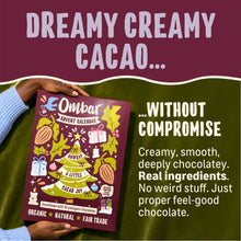 An Ombar organic cacao advent calendar is held against green fabric, with “Dreamy creamy cacao... without compromise” text promoting smooth chocolate, real ingredients, and feel-good indulgence.