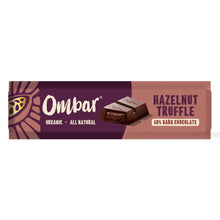 A purple and rose-colored Ombar organic dark chocolate wrapper shows a rich hazelnut truffle piece and reads “60% dark chocolate,” with a bold, indulgent tone.
