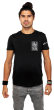 Man wearing a black t-shirt with a logo and text on a white background