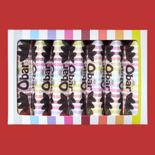 A box of six chocolate Catherine's Original Vegan Milk Chocolate O'bar bars sits on a red background, with colorful striped wrappers and bold lettering creating a playful, bright tone.