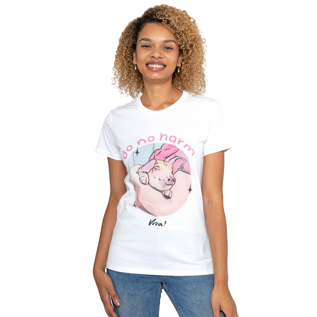 A woman wearing a white graphic t-shirt with a cartoon pig and the text 'do no harm' and 'Wim!', paired with blue jeans, against a plain white background