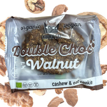 A Kookie Cat vegan Double Choc Walnut cashew and oat cookie, surrounded by walnut pieces on a white background.