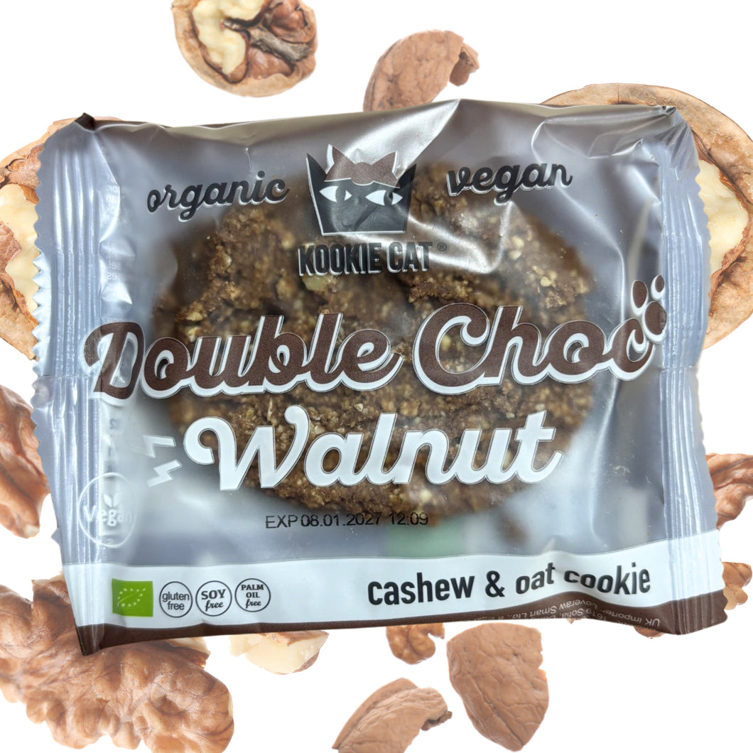 A Kookie Cat vegan Double Choc Walnut cashew and oat cookie, surrounded by walnut pieces on a white background.