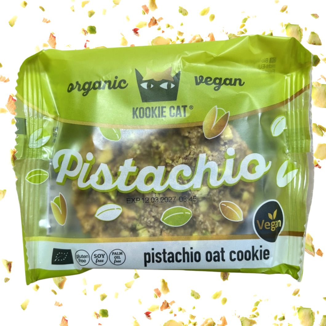 Green Cookie Cat vegan pistachio oat cookie wrapper, surrounded by scattered pistachio pieces; playful, fresh packaging highlights organic ingredients.