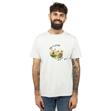 A man with a beard and tattoos wearing a white crewneck t-shirt with a circular graphic of two watercolour pigs in a field and the text 'pigs are friends, not food Viva!