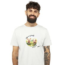 A man with a beard and tattoos wearing a white crewneck t-shirt with a circular graphic of two watercolour pigs in a field and the text 'pigs are friends, not food Viva!