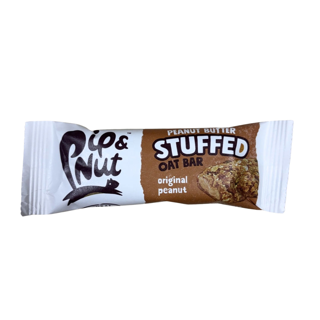 A Pip & Nut peanut butter-stuffed oat bar in brown-and-white packaging rests on a white background, with a photo of the textured bar.