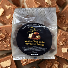 Packaged vegan chocolate fudge with Taffy and Co branding on a background of fudge pieces.