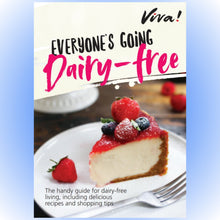 A slice of berry-topped cheesecake on a plate beneath a “Viva! Everyone’s going dairy-free” guide cover, promoting dairy-free recipes.
